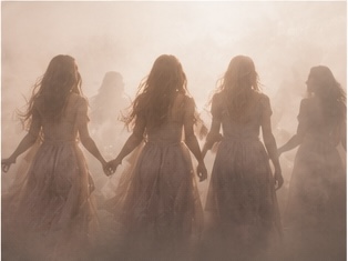 Four women holding hands in warm fog, seen from behind