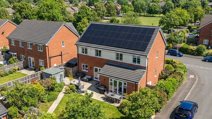 Modern UK house with a full array of black solar panels on a south-facing roof