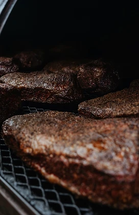 Brisket inside a smoker at low light