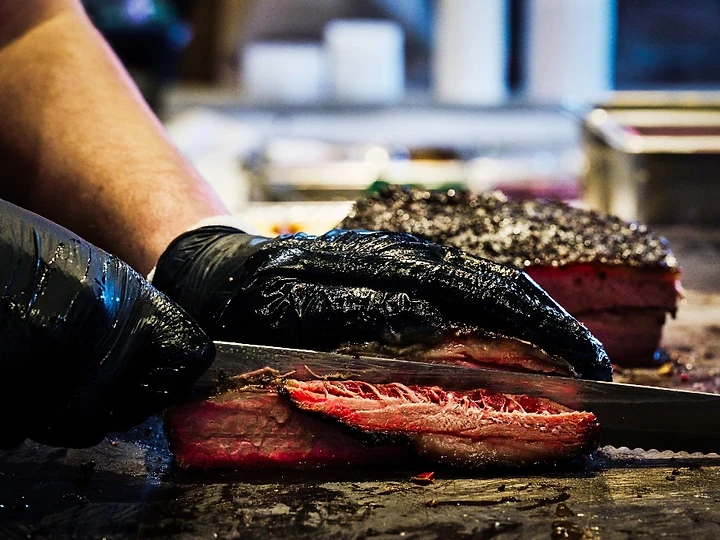 Slicing smoked brisket over live fire