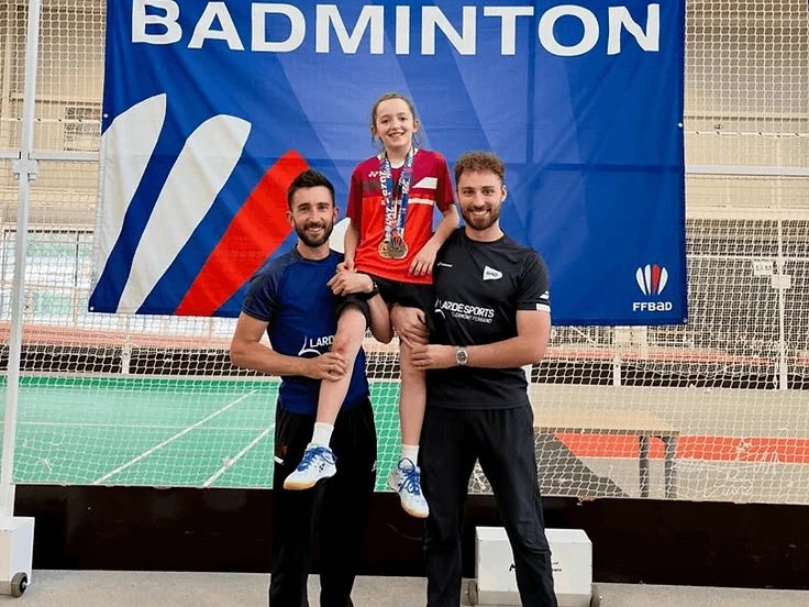 Jeune joueuse du Volant des Dômes médaillée aux Championnats de France de badminton avec son encadrement