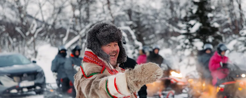 Local guide in traditional Arctic clothing on a snowmobile tour in Tromsø
