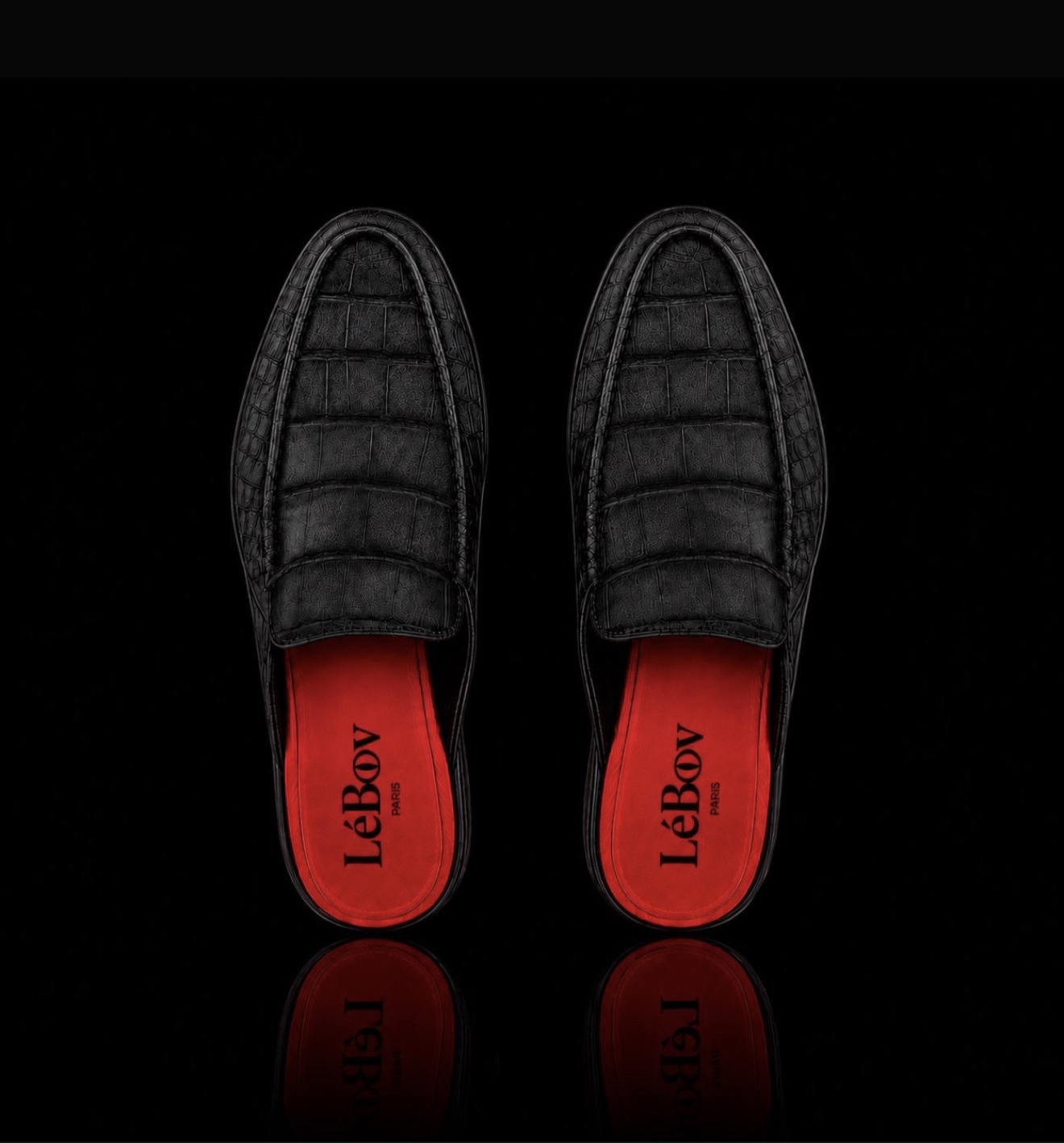 A pair of LéBov Paris croc-embossed brown leather mules against a black background.