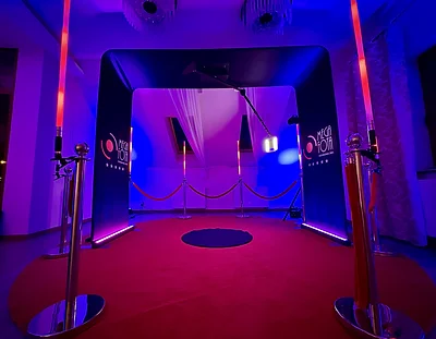 Fotobudka 360 Overhead MegaFota z łukowym tłem, czerwonym dywanem i pionowymi światłami LED na Christmas Party PDC Logistics
