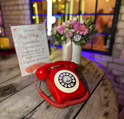 Telefon życzeń audio w czerwonym retro wydaniu na drewnianym stole na weselu | MegaFota Szczecin
