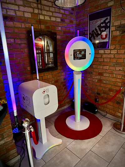 Fotobudka Mini MegaFota z pierścieniem LED RGB na czerwonym dywanie na tle ceglanej ściany