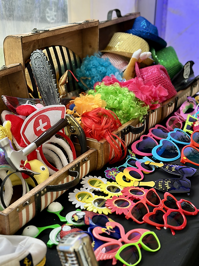 Drewniana skrzynia z rekwizytami fotobudki retro — kolorowe peruki, błyszczące kapelusze i zabawne okulary na festynie pracowniczym DB Port Szczecin | MegaFota Szczecin