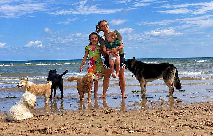 Eva with her family and five rescue dogs on the beach