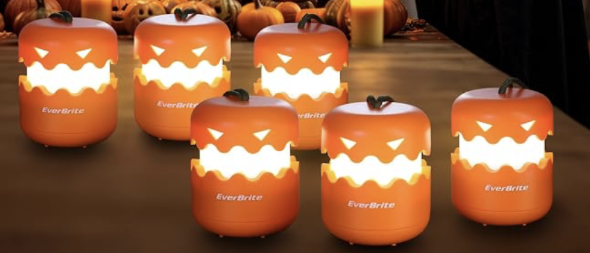 Glowing orange LED pumpkin lanterns on a table