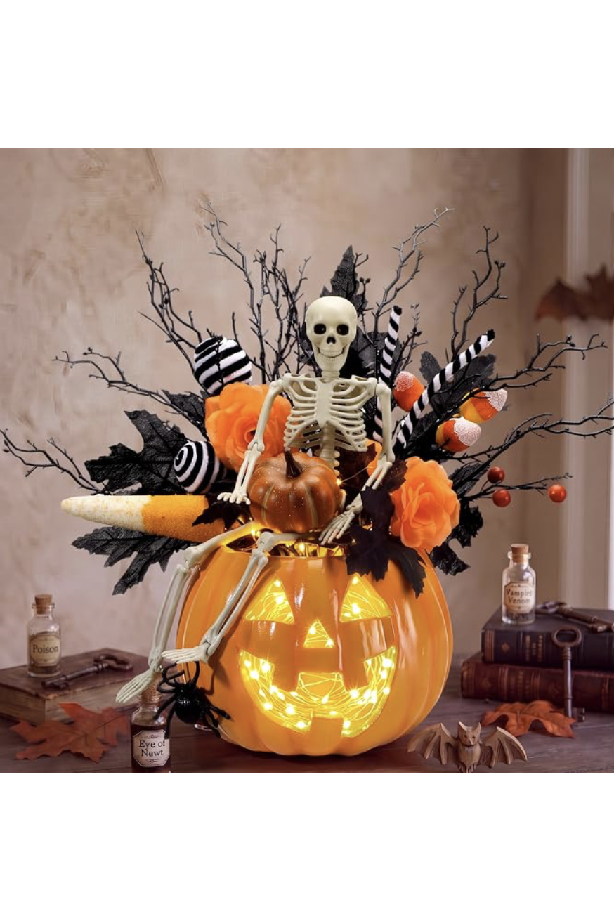 Lighted jack-o-lantern table centerpiece with a skeleton, candy corn, and black branches