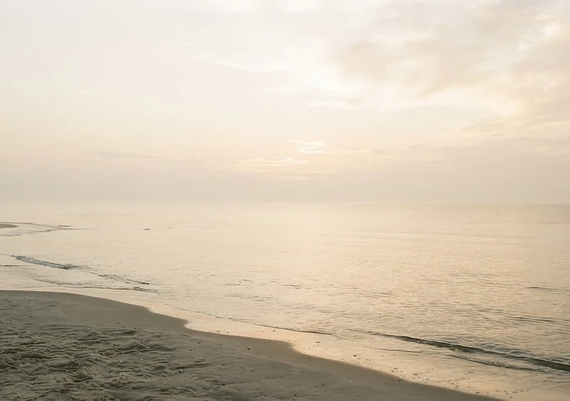 A calming sunrise over a still ocean, symbolizing new beginnings