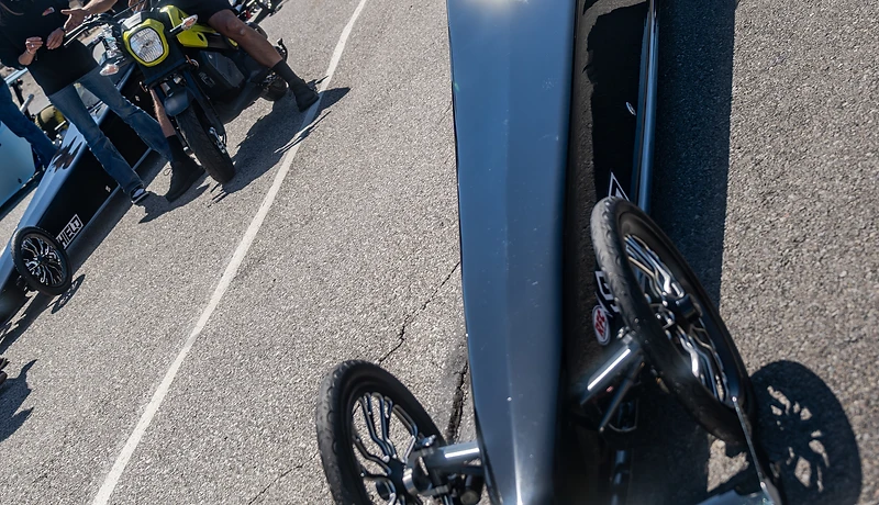 Wide view of racers and crews filling the Top Gun Dragstrip staging lanes below the Fallon hills