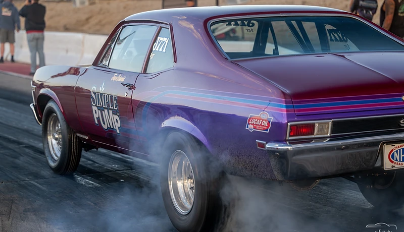 Dragster driver raising both arms after a pass at Top Gun Dragstrip