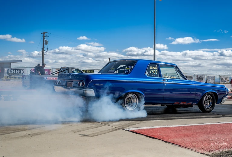 Blue drag racing pickup performing a burnout at Top Gun Dragstrip