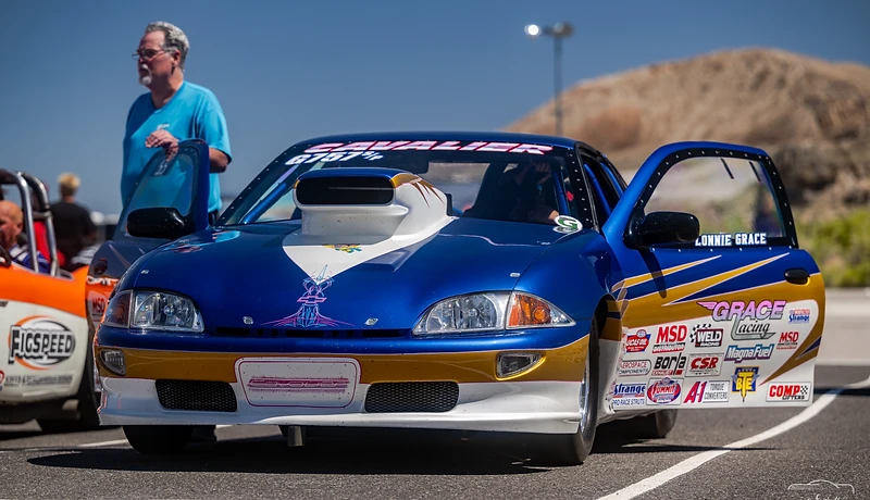Blue drag racing car and driver between runs in the Top Gun Dragstrip pits