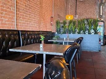 Tufted leather booths and warm pendant lighting inside Barbon Asadero