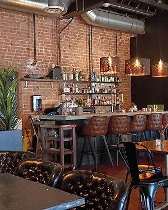 Concrete bar with tufted stools and exposed brick at Barbon Asadero