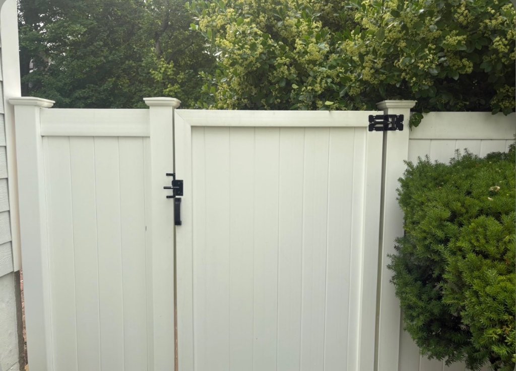 Same white vinyl fence and gate restored to a bright clean finish after soft washing by Apex Property Services