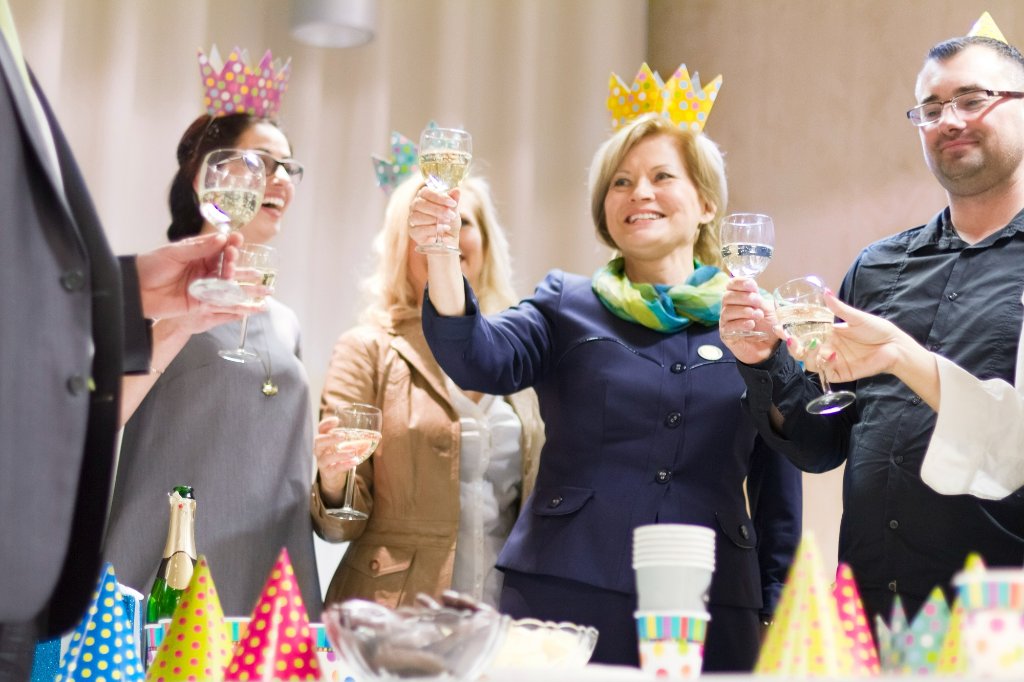 Firemní oslava s přípitím a party čepicemi