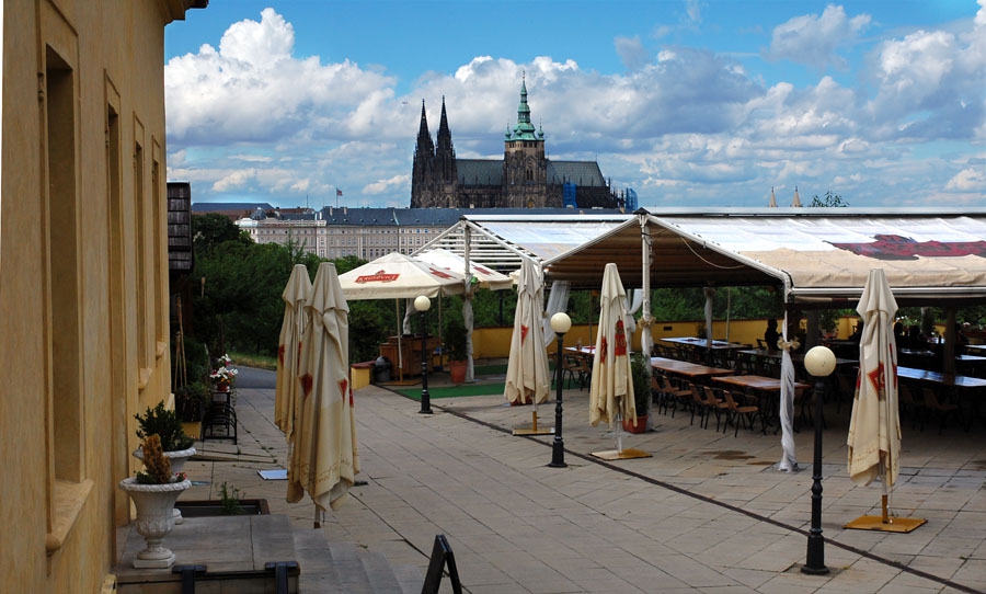 Terasa – prázdné stoly s výhledem na hrad