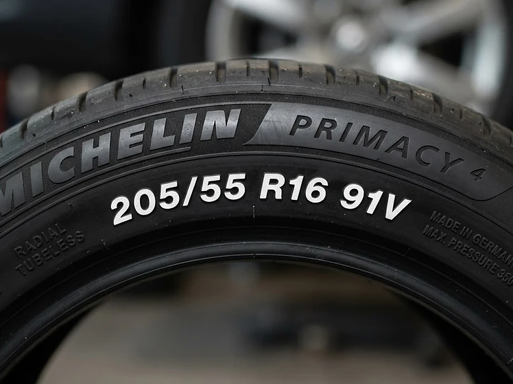 Close-up of a car tyre sidewall showing the size code 205/55 R16 91V