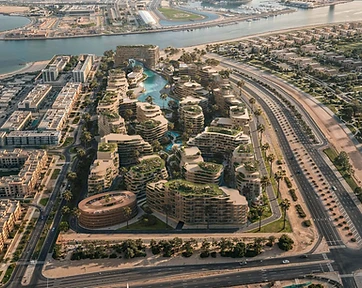 Bird's-eye aerial render of the Wadi project showing organic residential clusters around a serpentine waterway, a circular parking structure and a perimeter highway