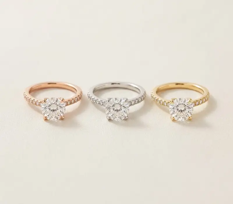 Three engagement rings in rose, white and yellow gold