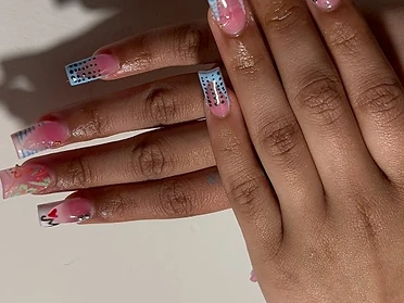 Long square French manicure with multicolor gradient tips, cow print accents, and iridescent gems.