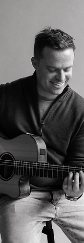 Tim playing acoustic guitar, black and white