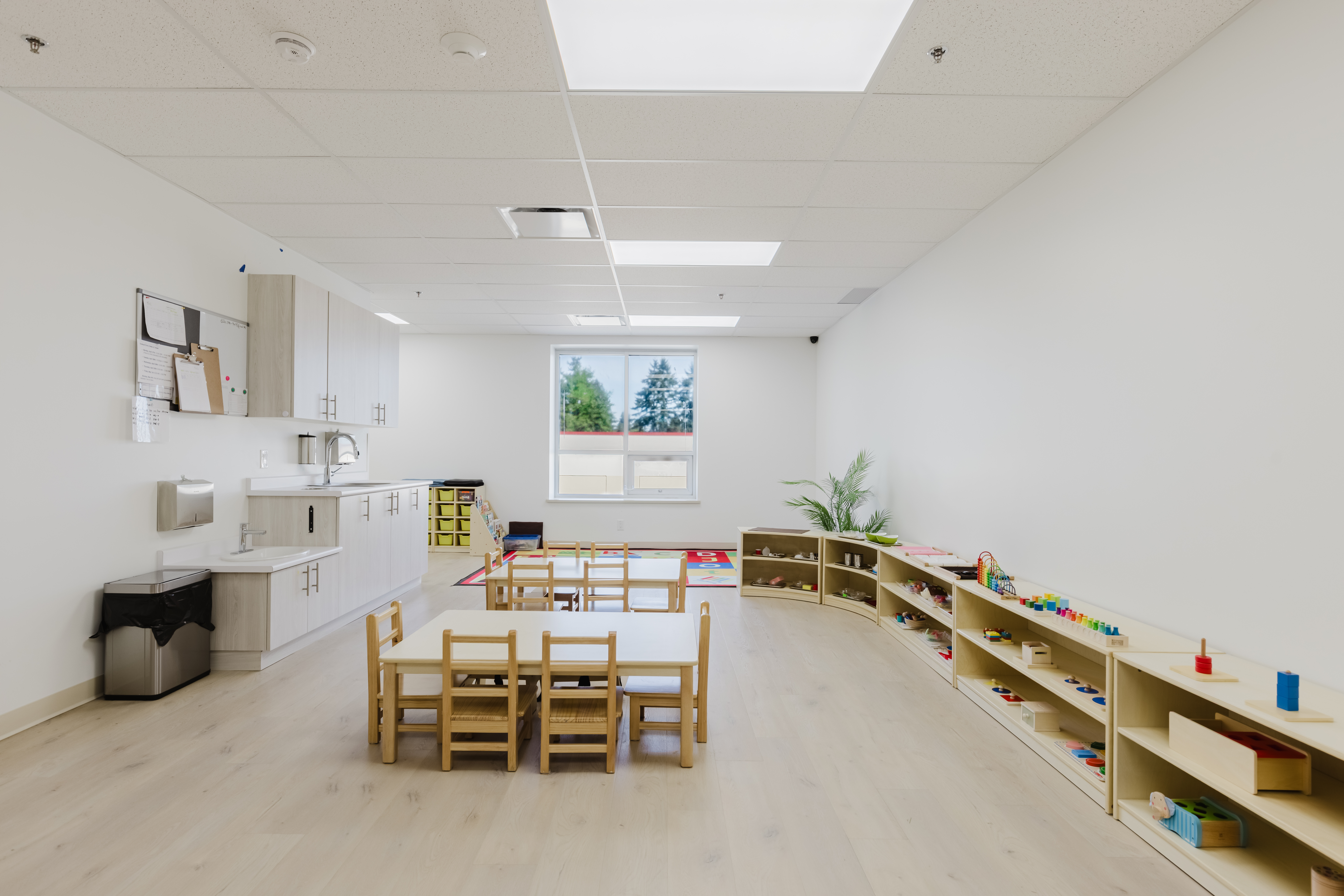 Clean, well-lit Kidzville classroom with curved shelves and Montessori materials