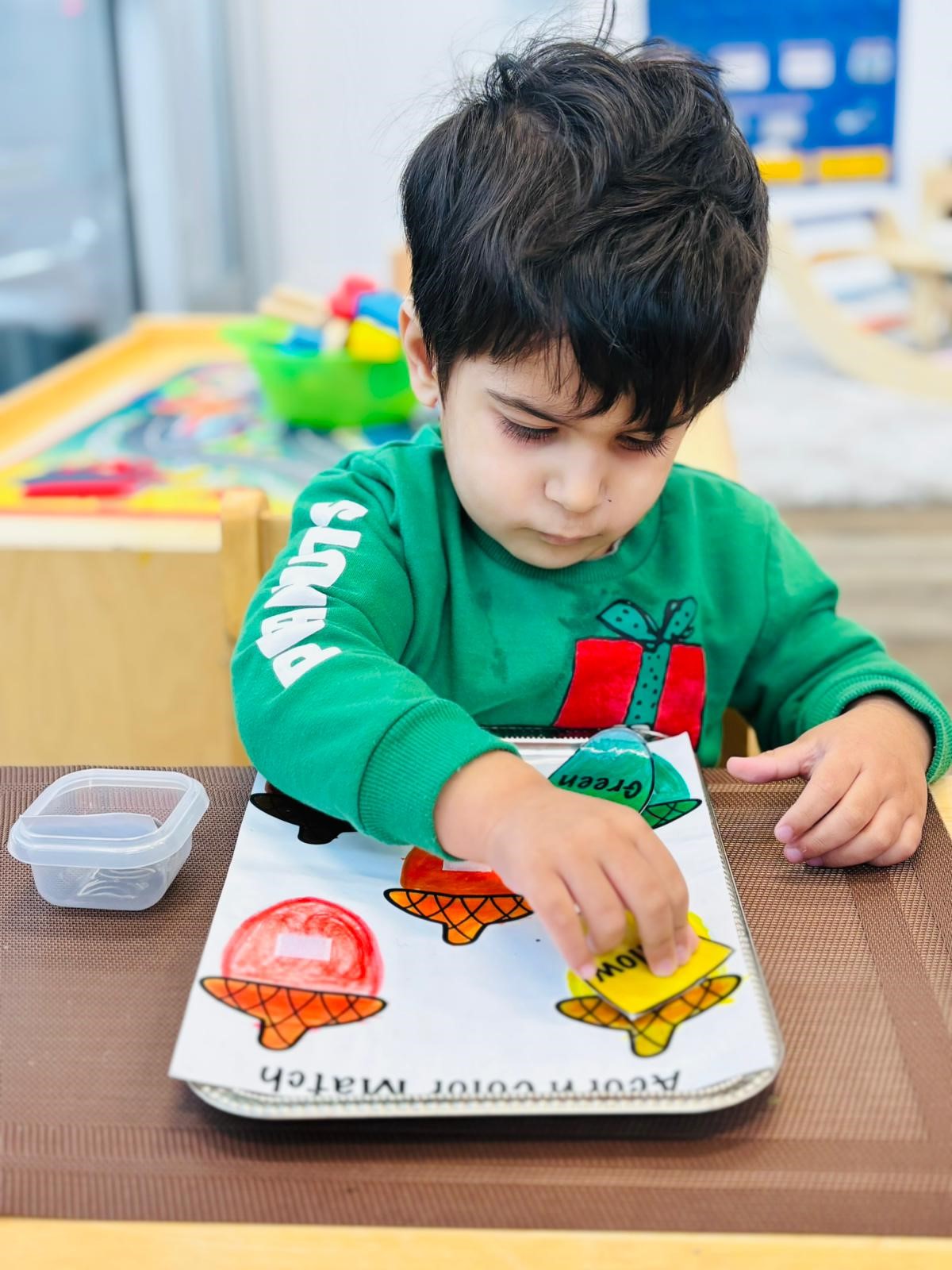 A child matching coloured acorns during a Montessori activity at Kidzville