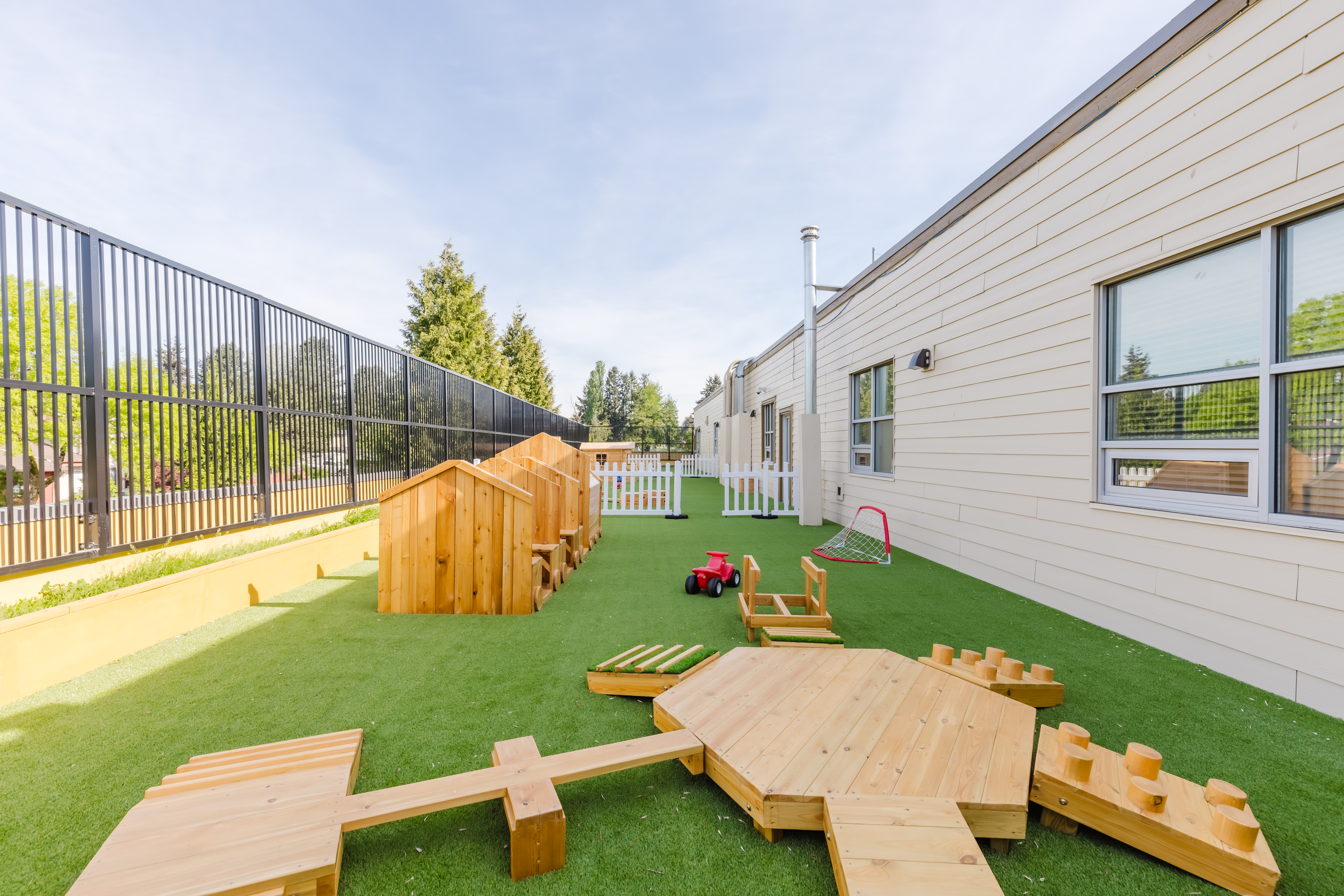 Spacious outdoor area with wooden climbing structures and balance equipment at Kidzville