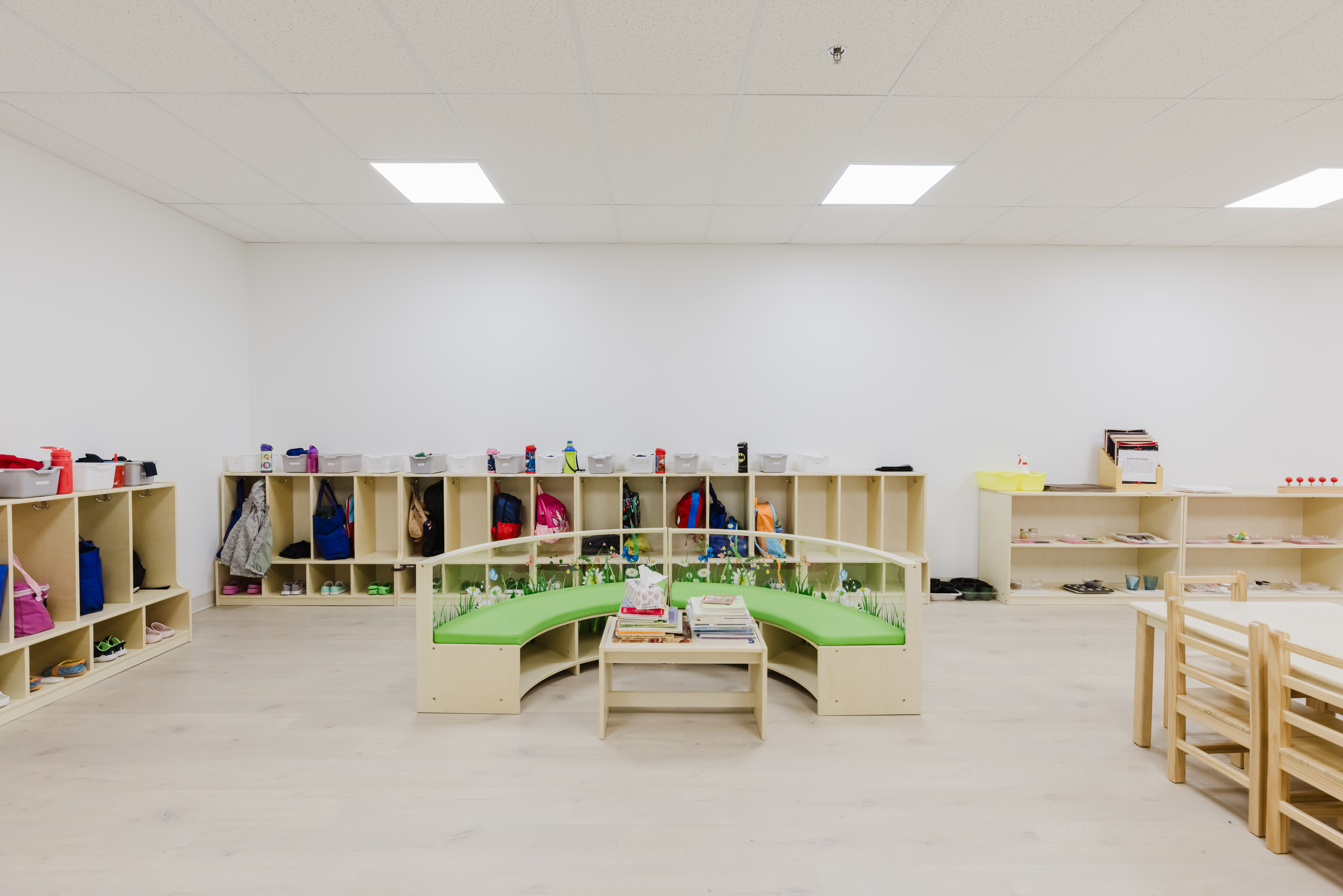 Kidzville classroom with cubby storage, reading bench and Montessori shelves
