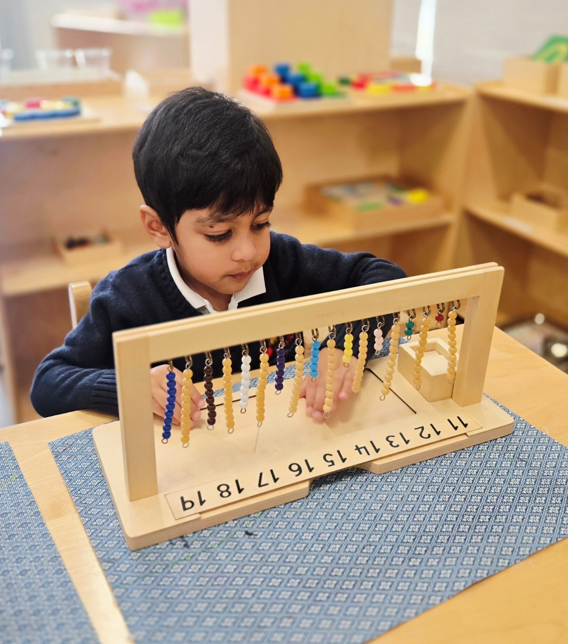 Child working with a Montessori bead chain for mathematics at Kidzville