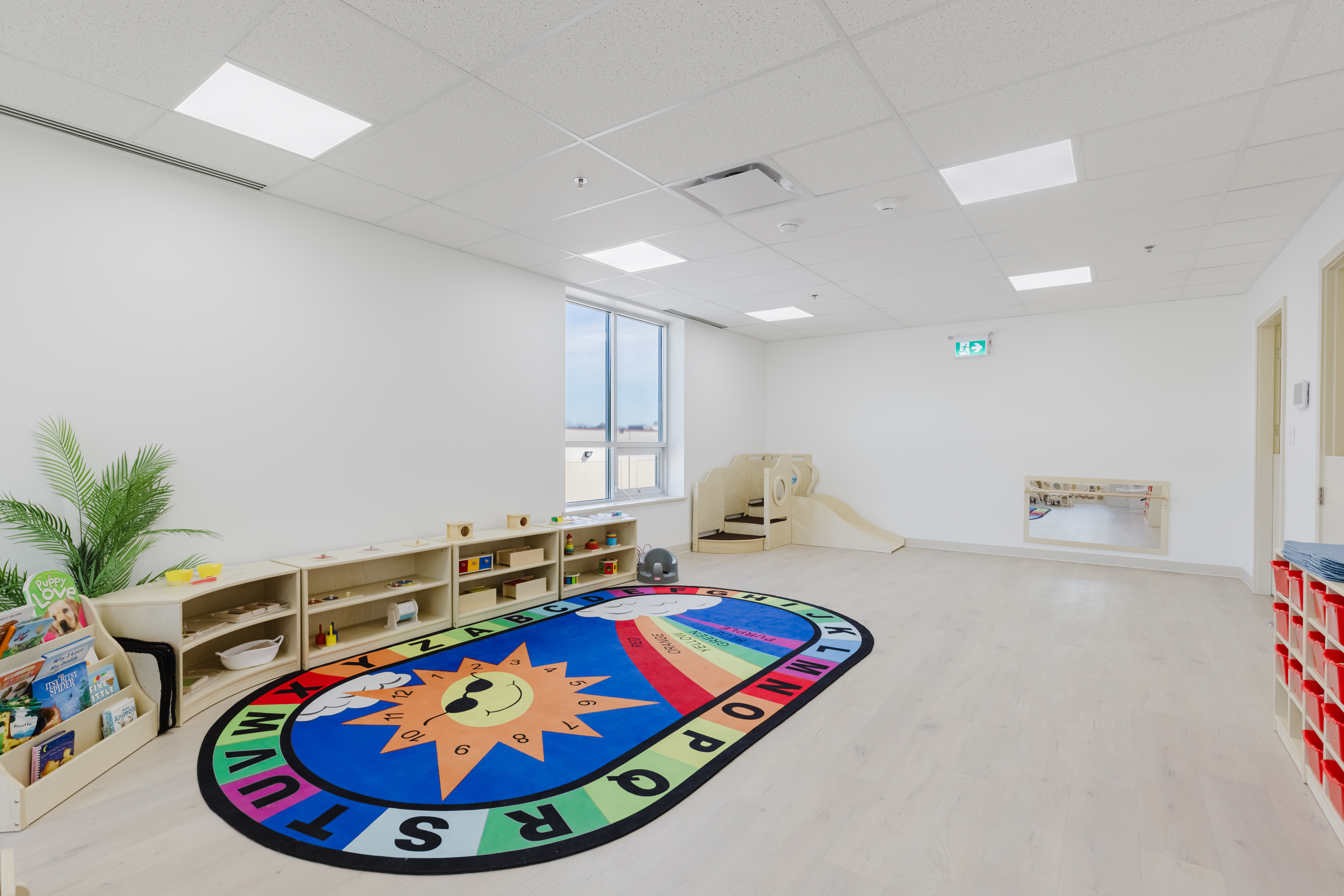 Infant program room with crib area and kitchen at Kidzville Learning Centre