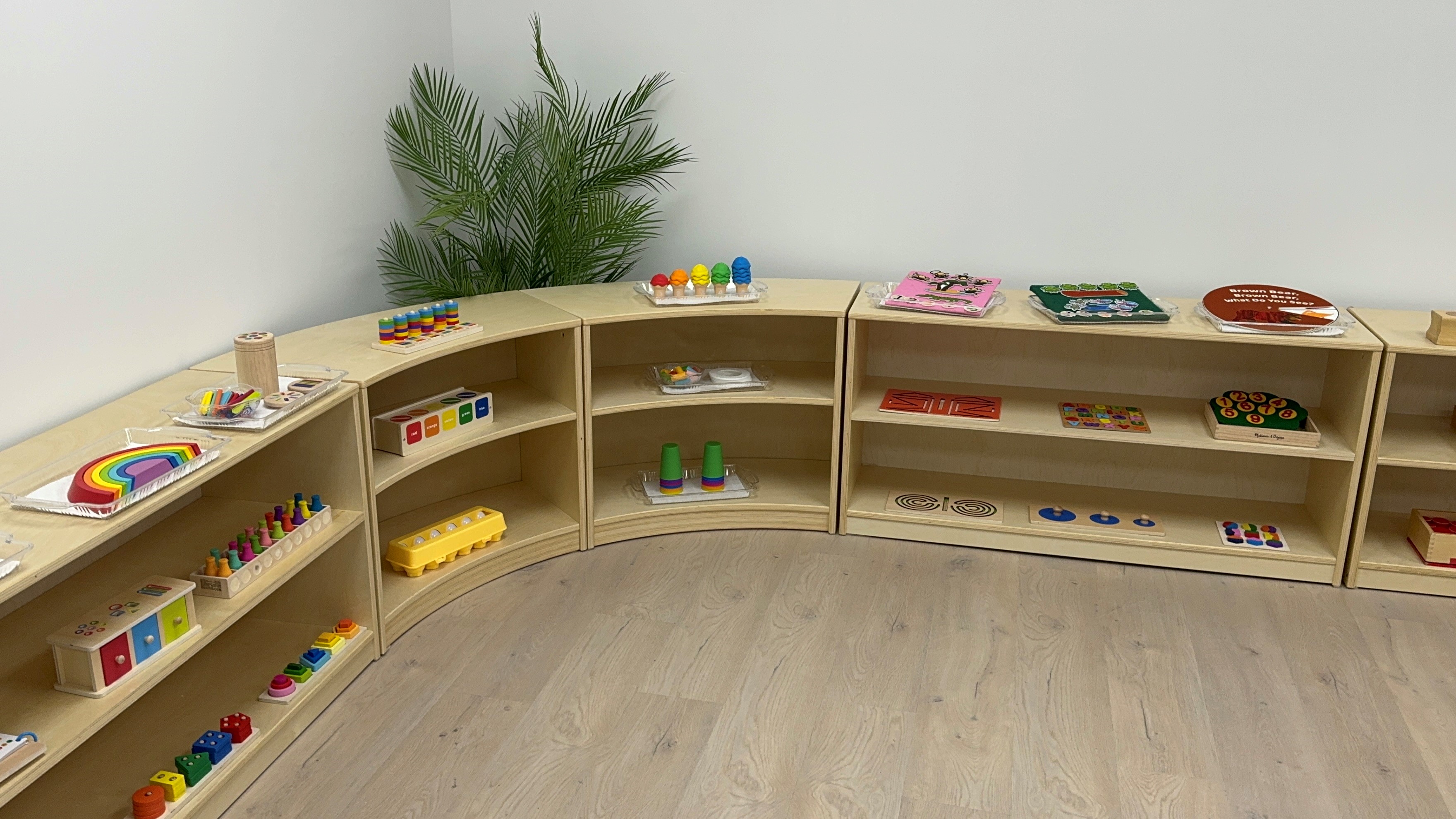 Montessori learning materials on curved shelving in a Kidzville classroom