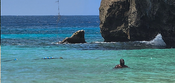 Traveler swimming in turquoise coastal water