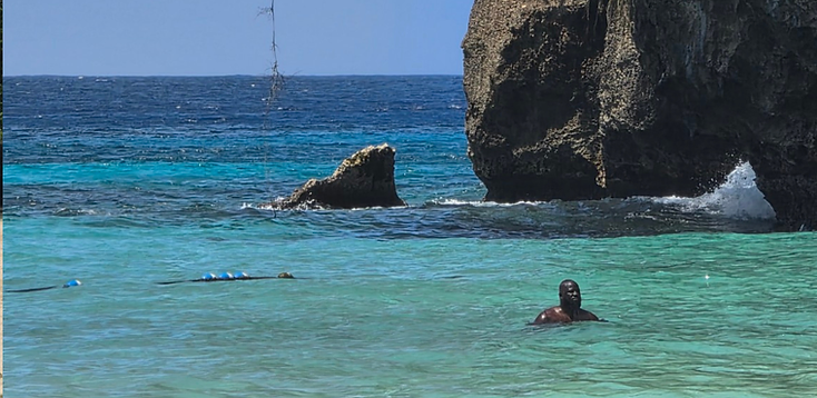 Traveler swimming in turquoise coastal water — the kind of place your three destinations might be.