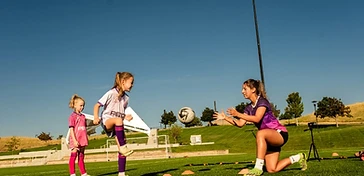 Female soccer athletes training together on the field