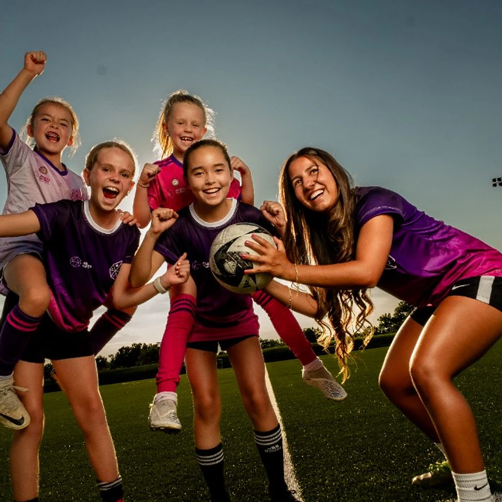 Young female soccer player training on the field