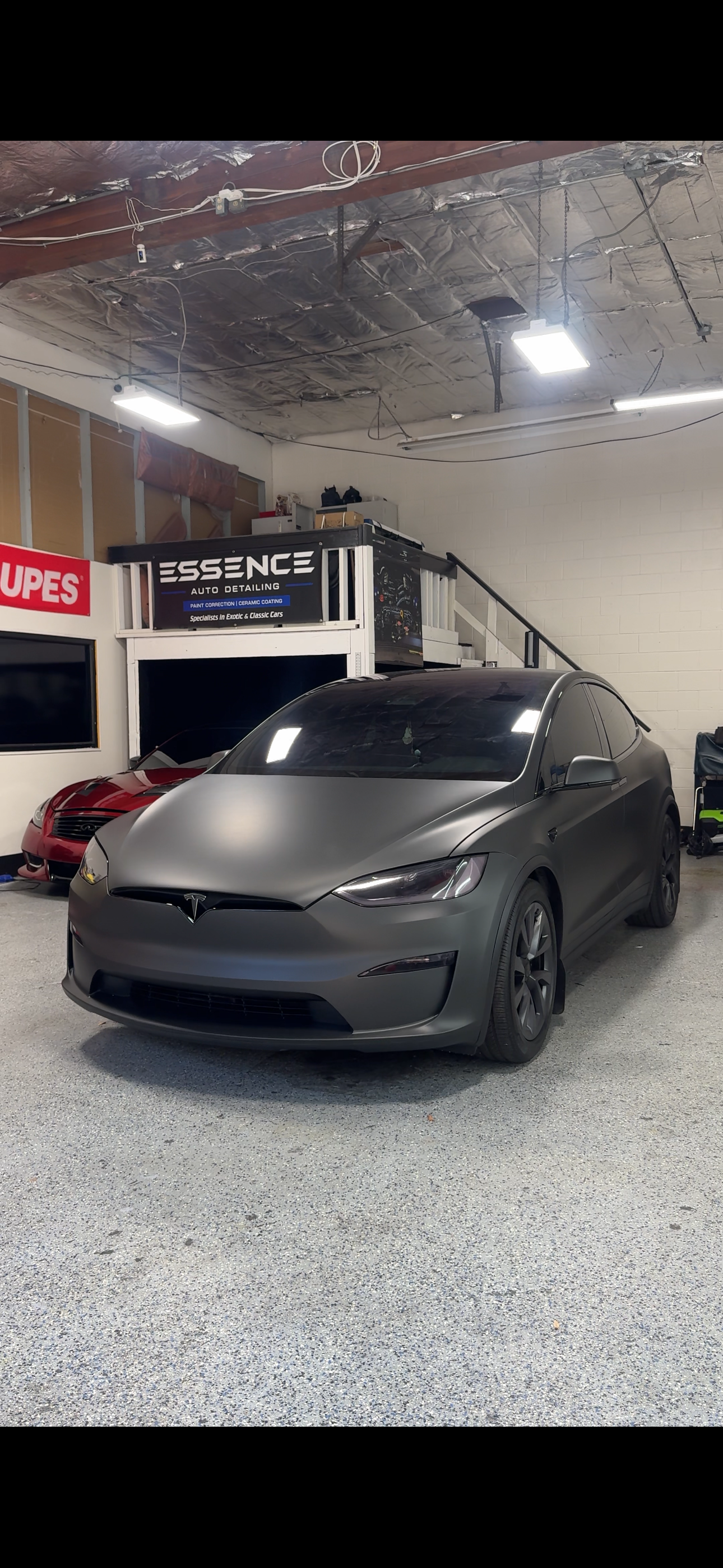 Matte black Tesla Model X in the Essence studio