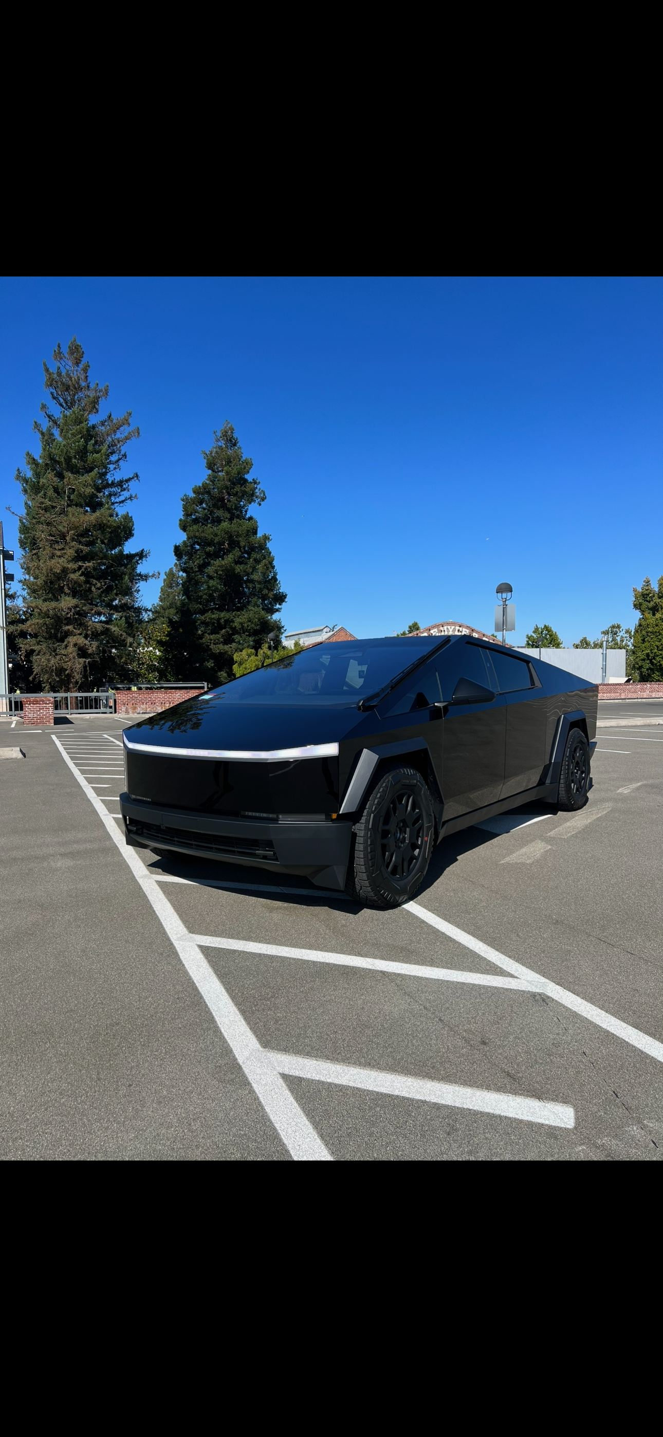 Glossy black Tesla Cybertruck parked outdoors