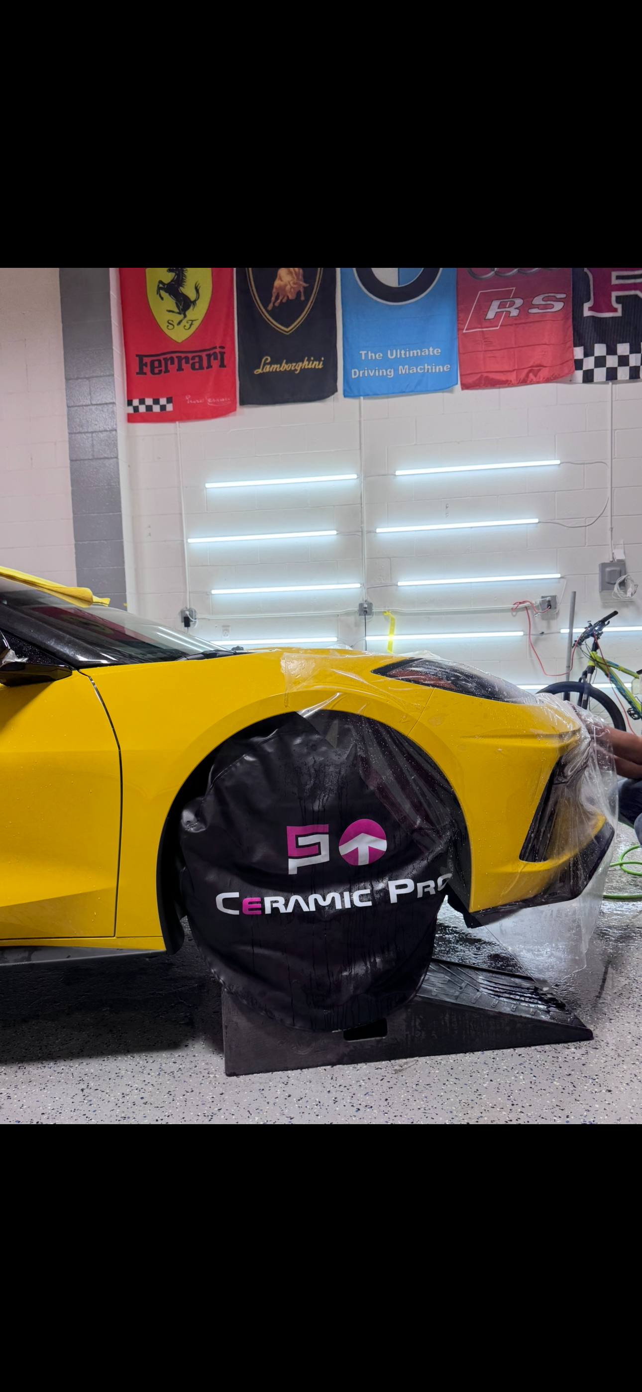 PPF installation on a yellow sports car with brand banners