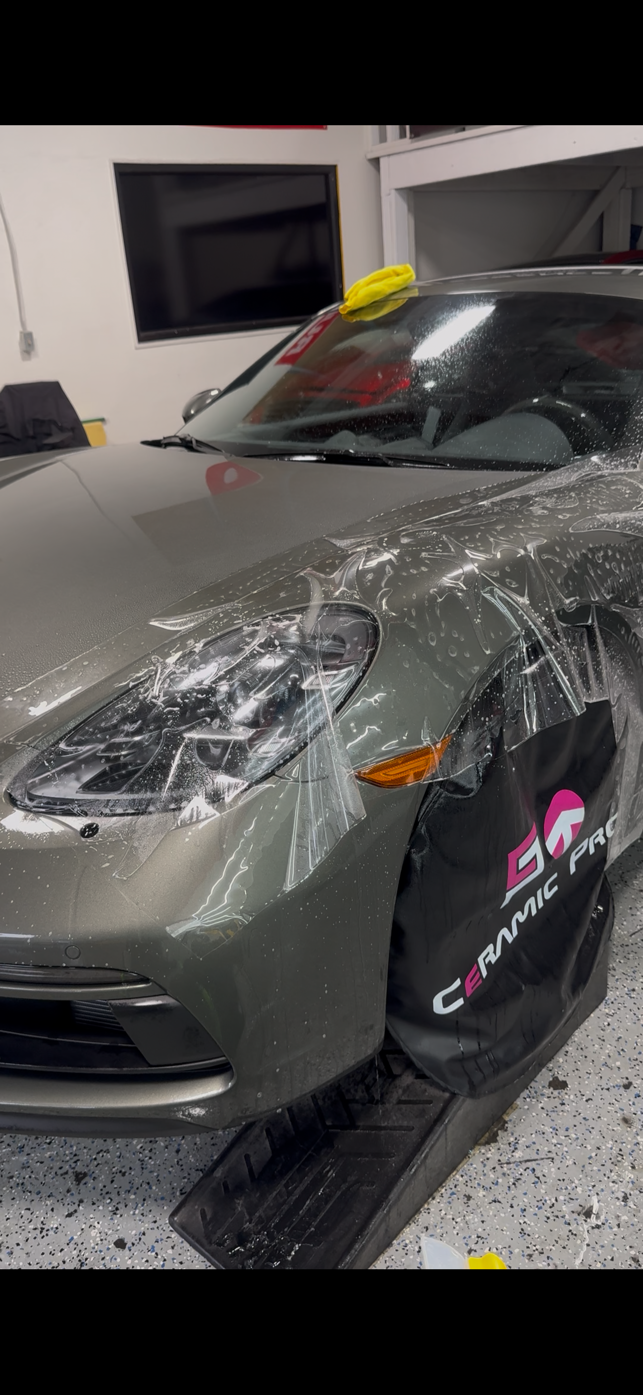 Paint protection film installation on a grey sports car