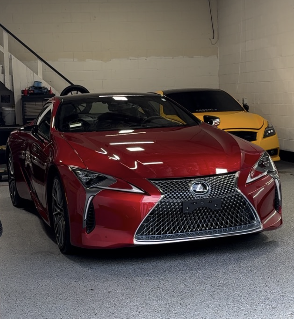 Red Lexus LC and yellow GT-R in garage