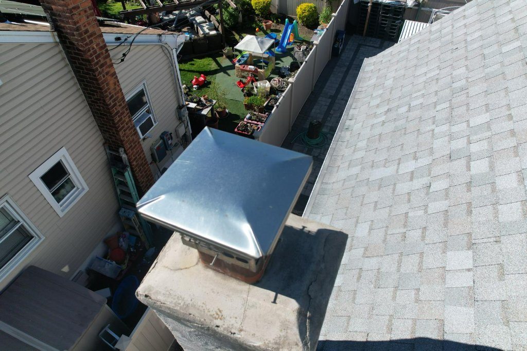 Newly installed metal chimney cap on a rooftop after the job.