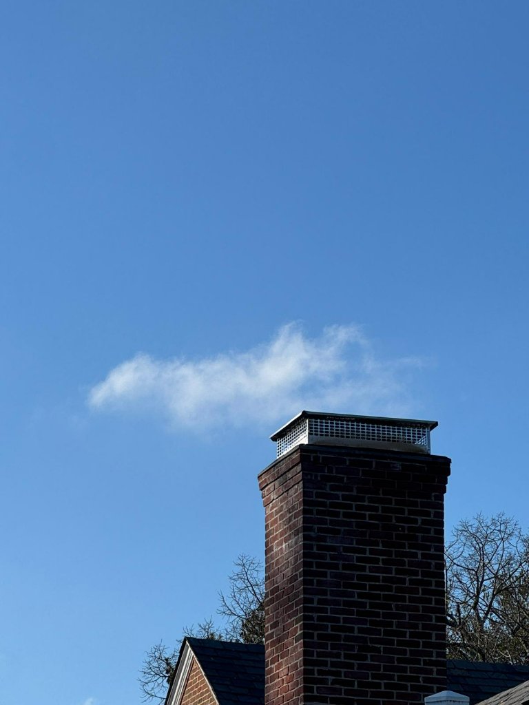 Newly installed chimney cap on a rooftop during a Summit service visit in Nassau County.