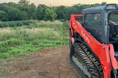 Triple M's Kubota track loader at an overgrown Missouri treeline with freshly cleared ground in front