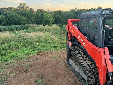Triple M's Kubota track loader at an overgrown Missouri treeline with freshly cleared ground in front