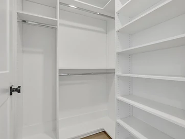 Closet with white adjustable shelving and double hanging rods